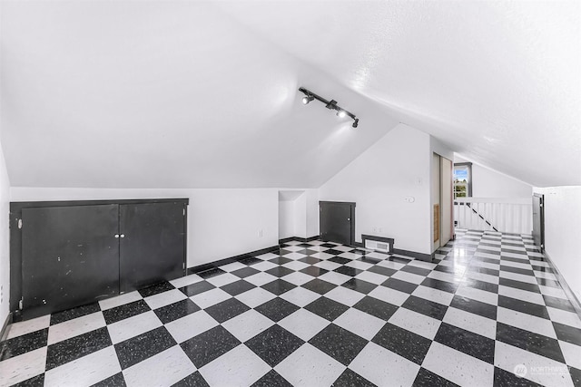 bonus room featuring lofted ceiling and a textured ceiling