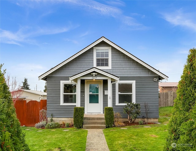 bungalow-style home with a front yard