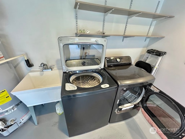 laundry room featuring water heater and independent washer and dryer