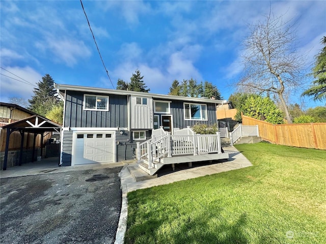 bi-level home featuring a garage, a front lawn, and a carport