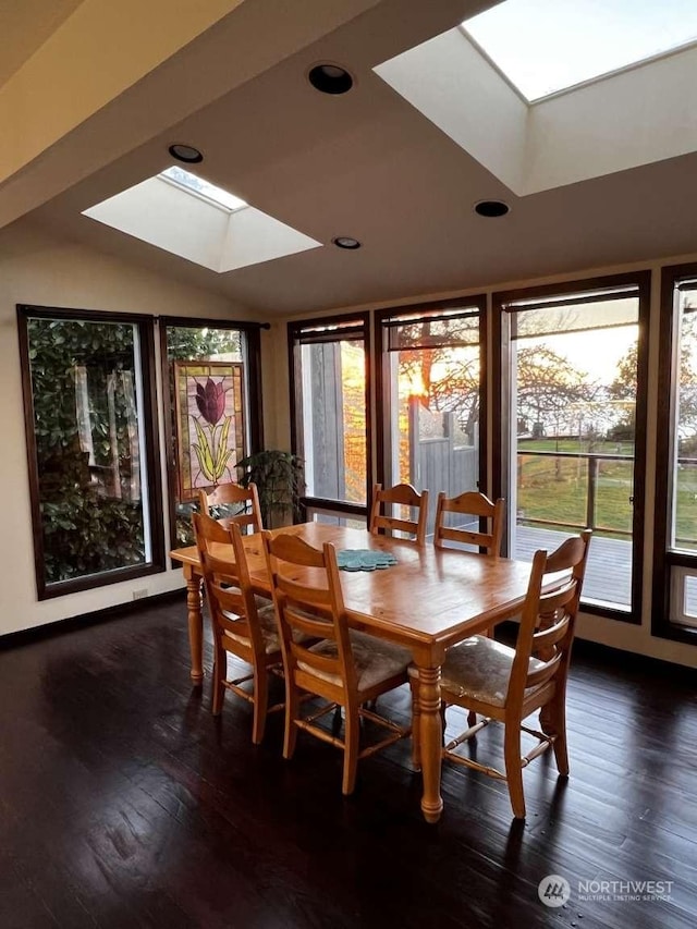 dining room featuring dark hardwood / wood-style flooring and vaulted ceiling with skylight