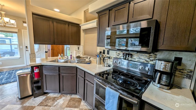 kitchen featuring a chandelier, sink, tasteful backsplash, appliances with stainless steel finishes, and dark brown cabinetry