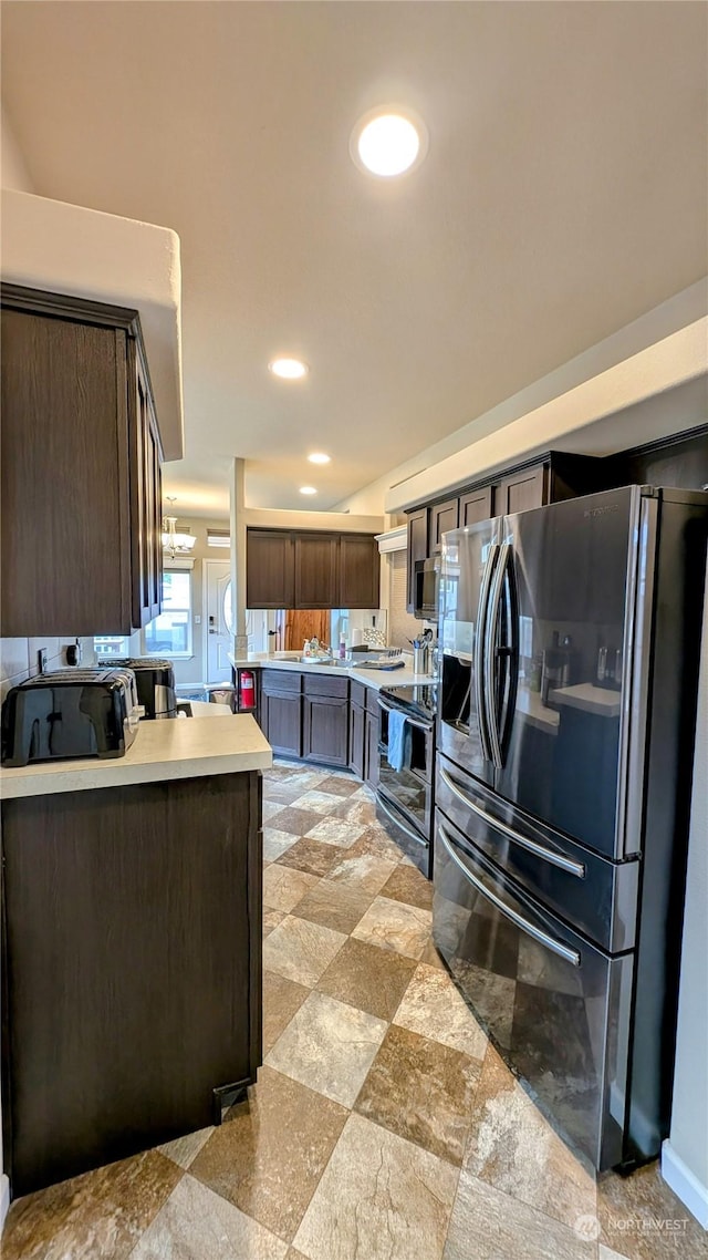 kitchen with stainless steel appliances, kitchen peninsula, and dark brown cabinetry