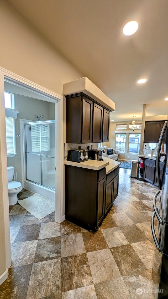 kitchen featuring black refrigerator and dark brown cabinetry