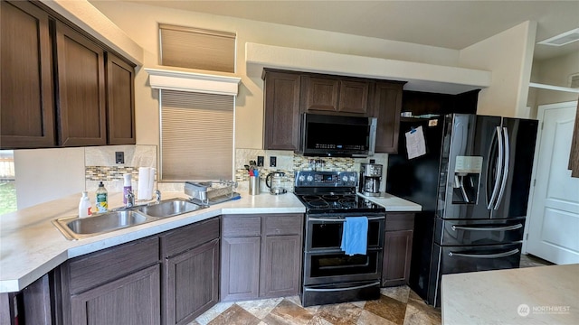 kitchen with backsplash, black appliances, dark brown cabinets, and sink