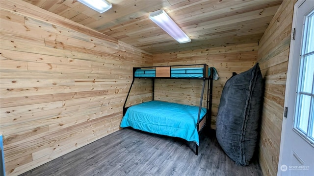 bedroom featuring wood walls, wooden ceiling, and hardwood / wood-style floors