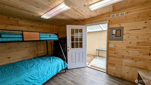 bedroom with wooden ceiling, wooden walls, hardwood / wood-style flooring, and vaulted ceiling