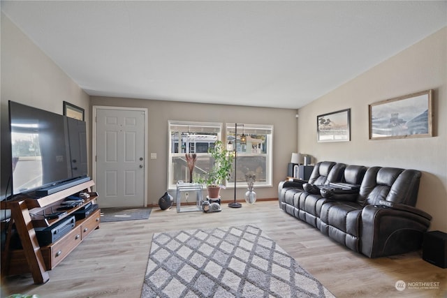 living room featuring lofted ceiling and light hardwood / wood-style flooring