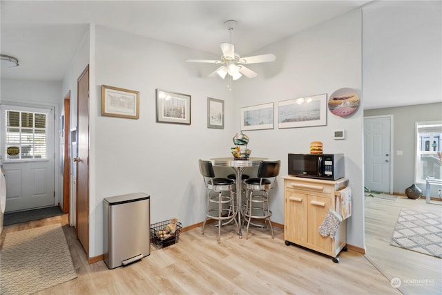 dining space with light wood-type flooring, ceiling fan, and lofted ceiling