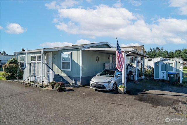 manufactured / mobile home featuring a storage shed and a carport