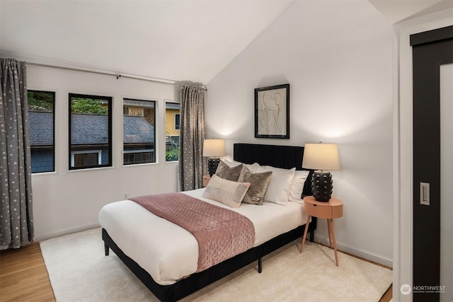 bedroom featuring lofted ceiling and light wood-type flooring