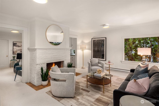 living room featuring baseboard heating, crown molding, and a stone fireplace