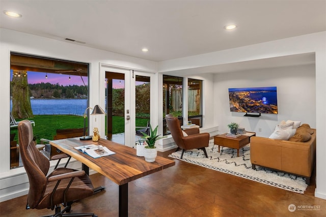 interior space featuring a water view, french doors, and concrete floors