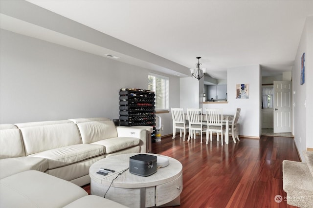 living room with a notable chandelier and dark hardwood / wood-style flooring