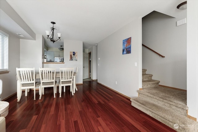 unfurnished dining area with a chandelier and dark hardwood / wood-style floors