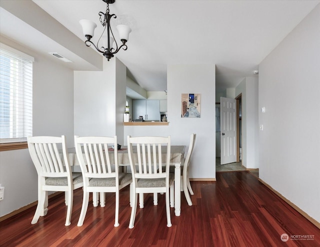 unfurnished dining area featuring a notable chandelier and dark hardwood / wood-style floors