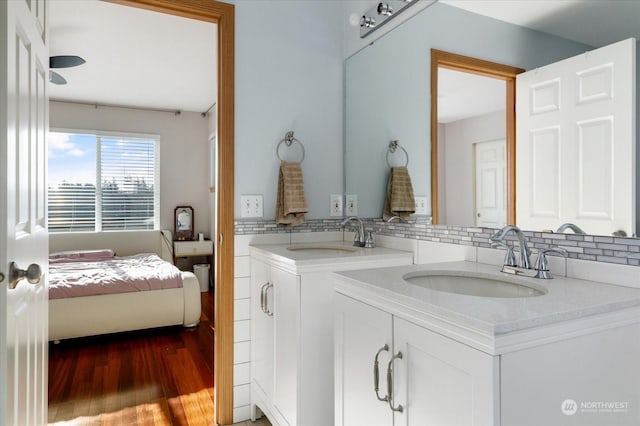 bathroom with vanity, hardwood / wood-style floors, and tasteful backsplash