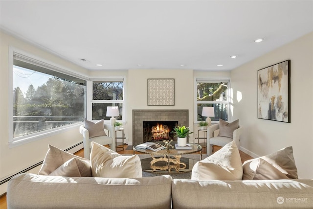 living room featuring a baseboard radiator, wood-type flooring, and a brick fireplace