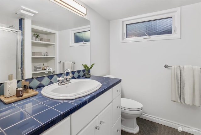 bathroom with built in shelves, vanity, toilet, and an enclosed shower