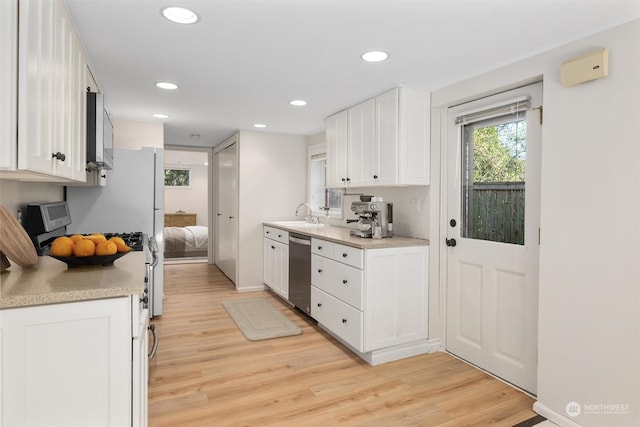 kitchen featuring white cabinetry, dishwasher, and light hardwood / wood-style flooring