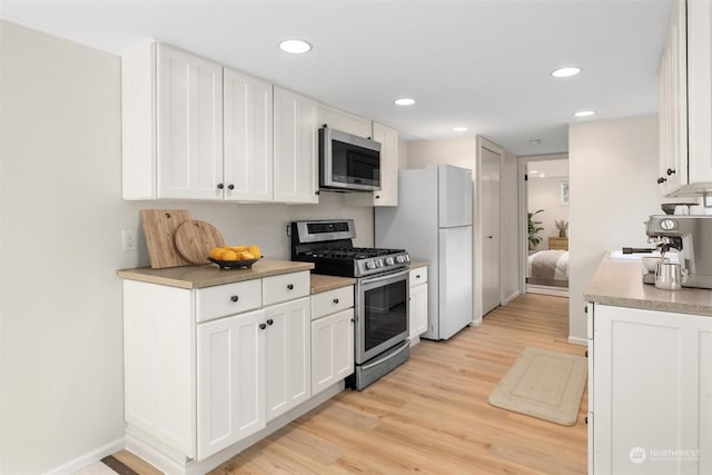 kitchen featuring white cabinetry, light wood-type flooring, and appliances with stainless steel finishes