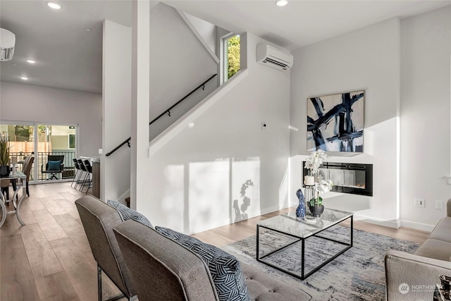 living room with a wall mounted AC and light wood-type flooring