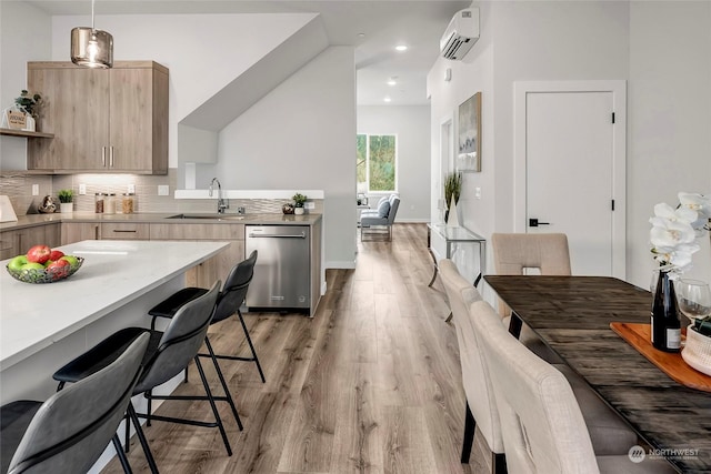 kitchen featuring pendant lighting, sink, a wall mounted AC, backsplash, and stainless steel dishwasher