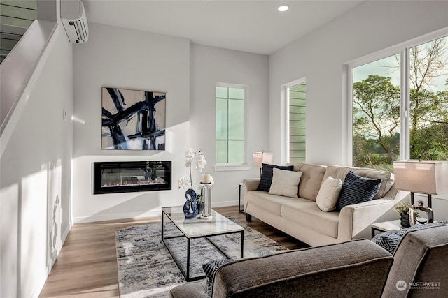 living room with light hardwood / wood-style floors and a wall unit AC