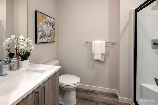 bathroom featuring vanity, hardwood / wood-style floors, and toilet