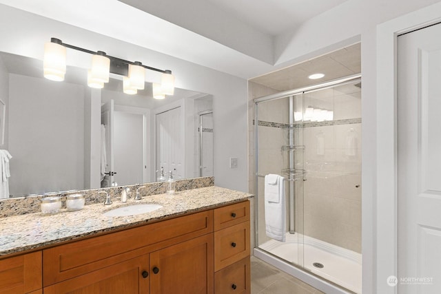 bathroom with vanity, an enclosed shower, and tile patterned flooring