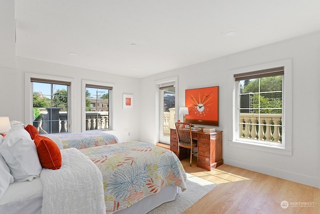 bedroom featuring access to exterior and light hardwood / wood-style floors