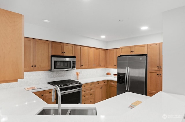 kitchen featuring tasteful backsplash, sink, stainless steel appliances, and kitchen peninsula