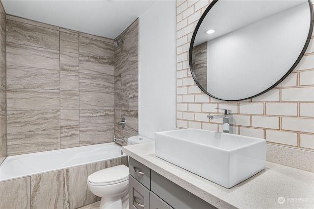 full bathroom with vanity, toilet, backsplash, and tiled shower / bath combo