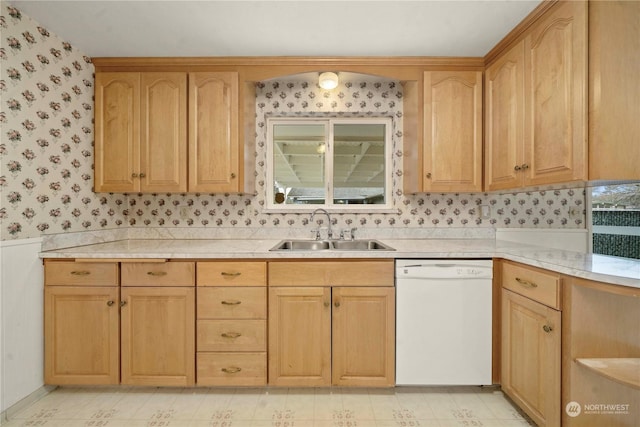 kitchen with light brown cabinets, sink, and white dishwasher