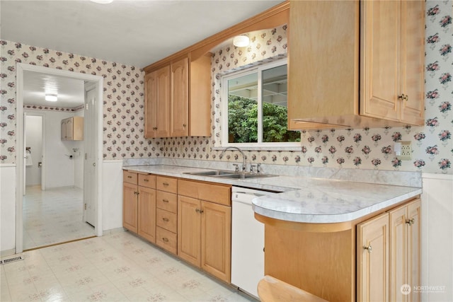 kitchen featuring light brown cabinetry, sink, and dishwasher