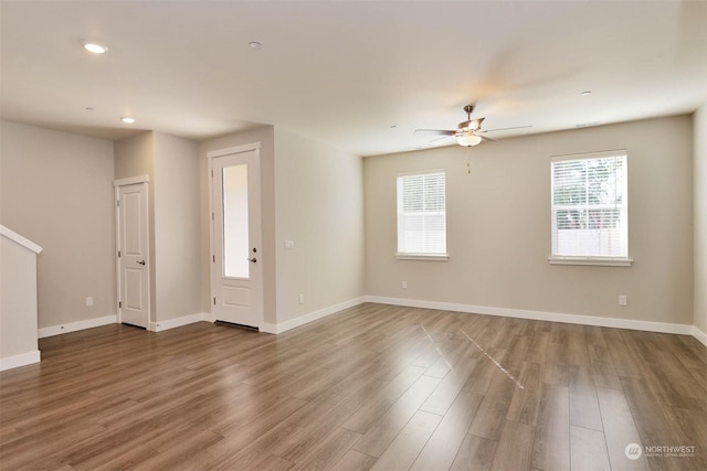 unfurnished room featuring hardwood / wood-style flooring, a healthy amount of sunlight, and ceiling fan