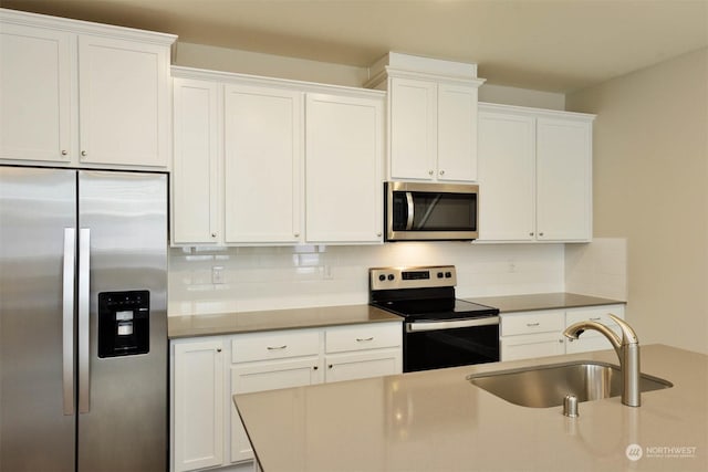 kitchen with white cabinetry, sink, backsplash, and stainless steel appliances