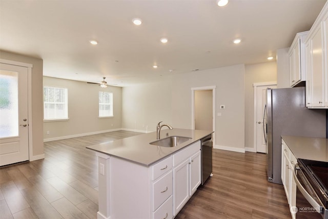 kitchen with white cabinetry, an island with sink, sink, and ceiling fan