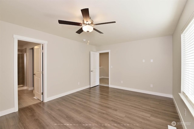 interior space with ceiling fan, a wealth of natural light, and dark hardwood / wood-style flooring