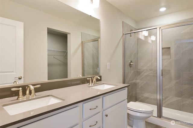 bathroom featuring an enclosed shower, vanity, and toilet