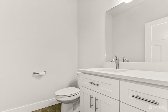 bathroom featuring vanity, wood-type flooring, and toilet