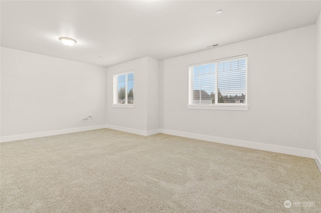 spare room with plenty of natural light and carpet flooring