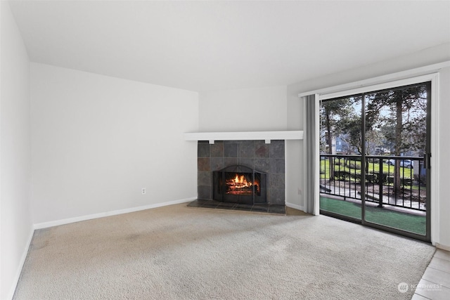 unfurnished living room featuring a tile fireplace and carpet