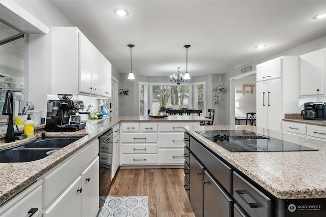 kitchen featuring white cabinets, an inviting chandelier, black appliances, and sink