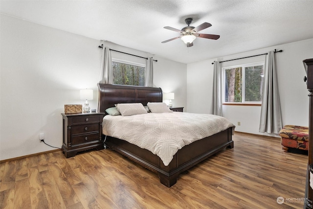 bedroom with hardwood / wood-style floors, a textured ceiling, and ceiling fan