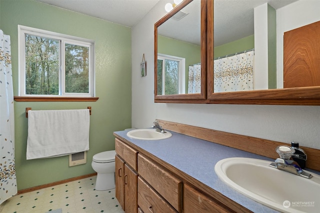 bathroom featuring toilet, a healthy amount of sunlight, and vanity