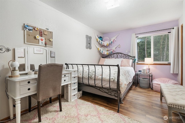 bedroom featuring a textured ceiling and light wood-type flooring