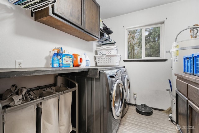 clothes washing area featuring washing machine and dryer and cabinets