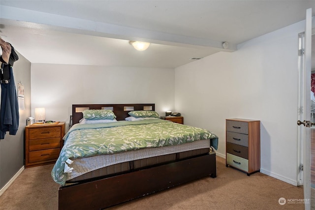 carpeted bedroom with beamed ceiling