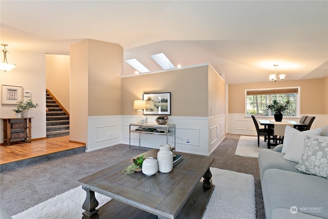 carpeted living room featuring a chandelier and vaulted ceiling